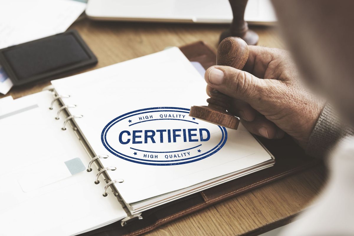 A certified professional stamping an official document