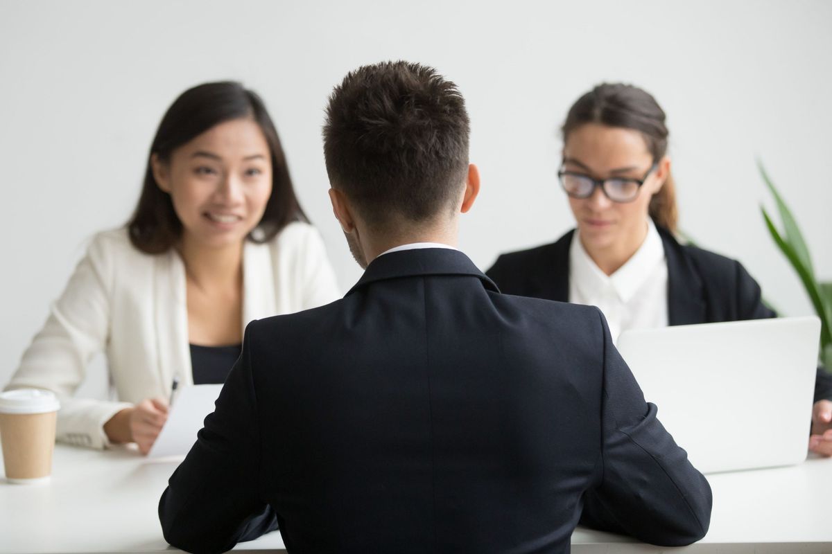 A candidate meeting with two interviewers in a bright office