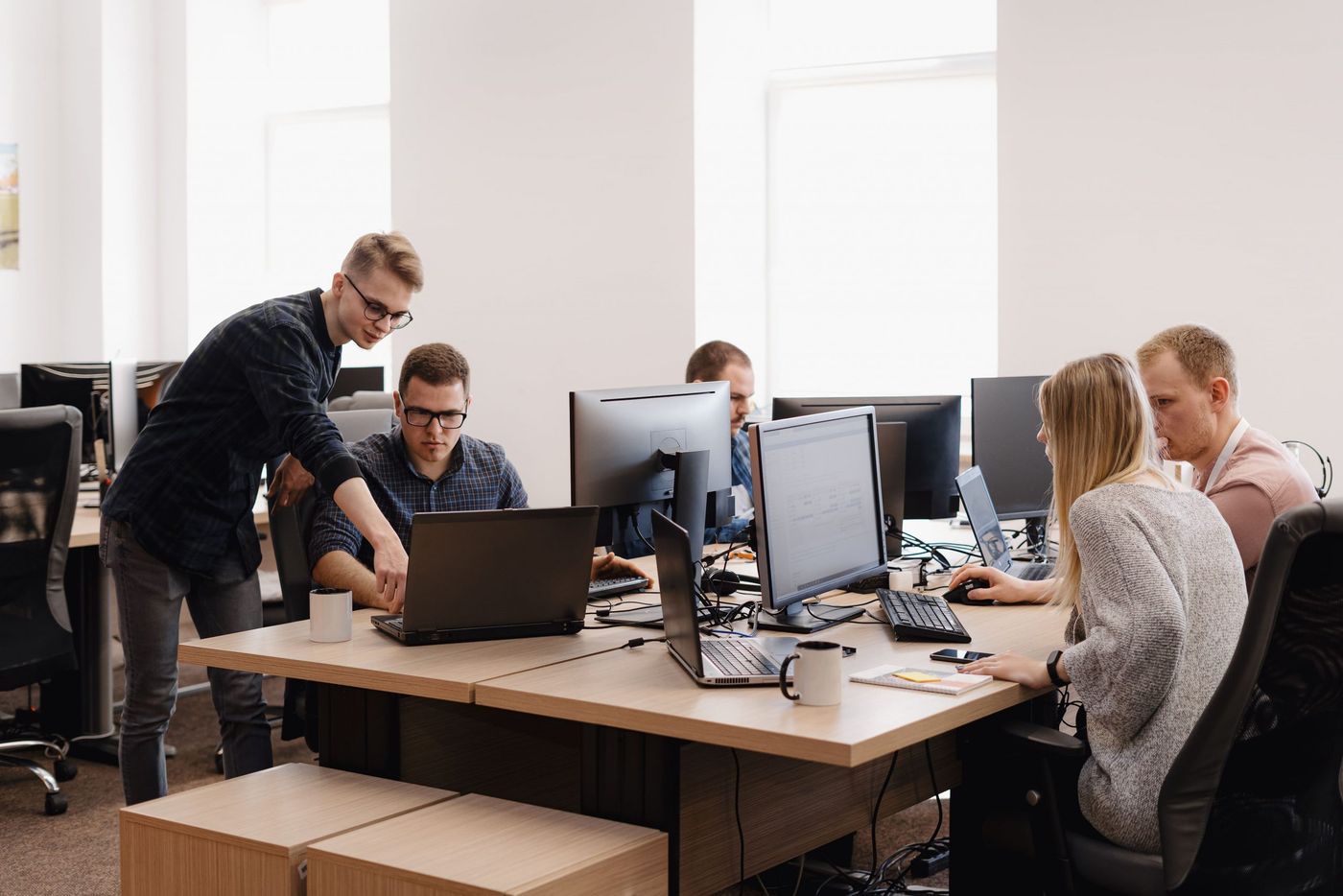 Engineering team collaborating around desktop computers