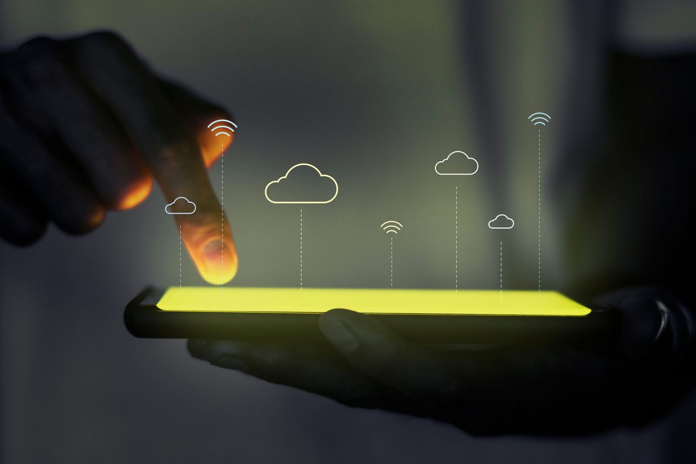 Hand holding a glowing tablet with cloud computing icons